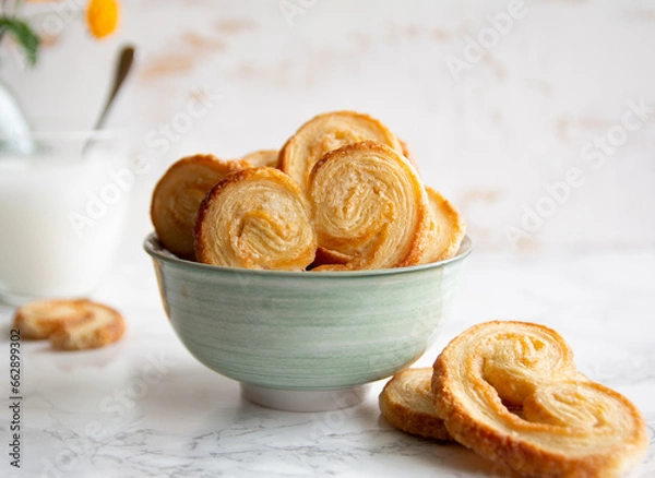 Obraz Puff pastry palmiers in a bowl on a white marble table. Homemade bakery for breakfast.