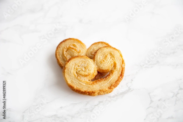 Obraz Two isolated Puff pastry palmiers on a white marble table.