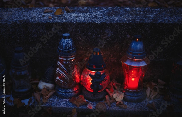 Obraz Votive candles lantern burning on the graves in Slovak cemetery at night time. All Saints' Day. Solemnity of All Saints. Hallows eve. 1st November. Feast of Saints. Hallowmas. Souls' Day in Slovakia
