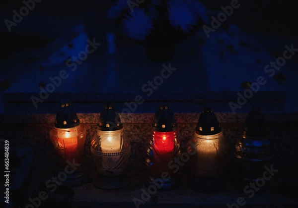 Obraz Votive candles lantern burning on the graves in Slovak cemetery at night time. All Saints' Day. Solemnity of All Saints. Hallows eve. 1st November. Feast of Saints. Hallowmas. Souls' Day in Slovakia