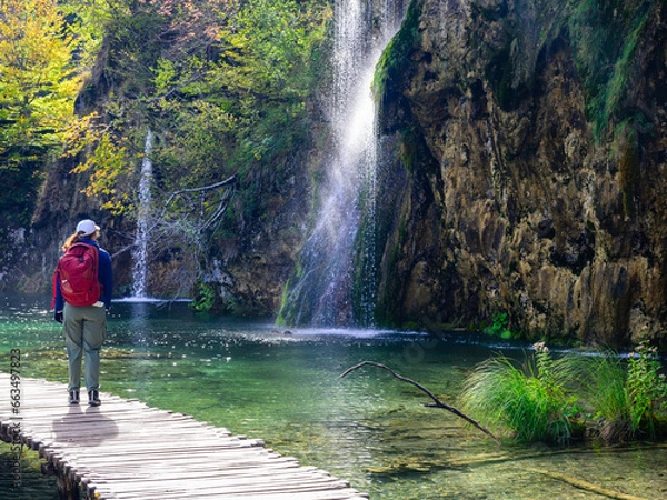 Obraz person walking by a waterfall in the plitvice lakes national park