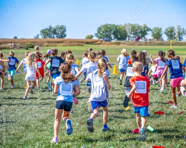 Fototapeta Group of elementary school age children running forward during a fundraising activity. 