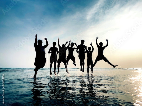 Fototapeta Boy jumping on the beach beach during sunset background. on horizon tropical relaxing outdoors vacation. sky surf summer clouds and light blue wave ocean.