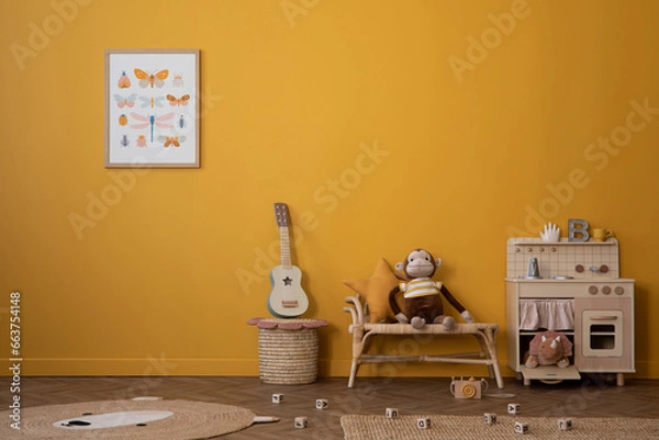 Fototapeta Warm and cozy composition of child room interior with mock up poster frame, children kitchen, braided bench, basket, guitar, bear carpet, wooden blocks and personal accessories. Home decor. Template.