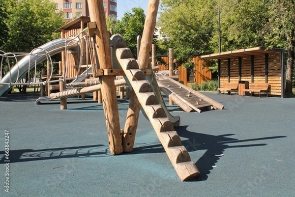 Obraz Wooden playground made of natural eco-friendly material in public city park. Modern safety children outdoor equipment. Concept of sustainable lifestyle and ecology. Children rest and games on open air