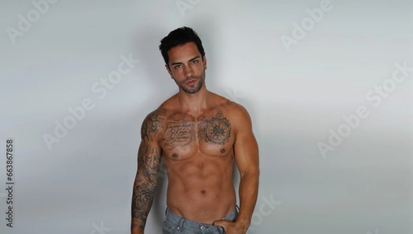 Fototapeta Shirtless muscular sexy male model, with empty copy space area for slogan, advertising or text message, against grey background.