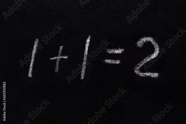 Fototapeta Simple math equation 1 1 2 written school board chalk. Blackboard equations one plus one equals two written black board background. 1 plus 1 equals 2 writing chalkboard background. Elementary school
