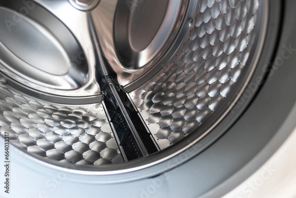 Fototapeta View into washing machine drum inside with stainless steel drum interior shows household equipment for cleaning clothes with dry cleaner and front loader for easy housework laundromat machine empty