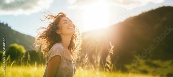 Fototapeta Backlit Portrait of calm happy smiling free woman with closed eyes enjoys a beautiful moment life on the fields at sunset