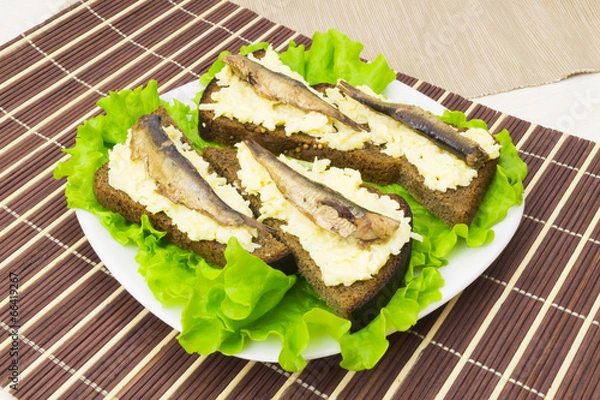 Obraz Sprats on bread with cheese and garlic