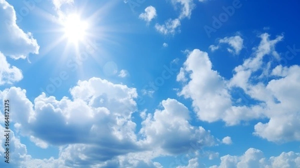 Fototapeta Clear blue skies with fluffy white clouds. Summer sunlight creates a beautiful and bright atmosphere. The wind gently moves the clouds, creating a scenic pattern in the sky. A perfect sunny day