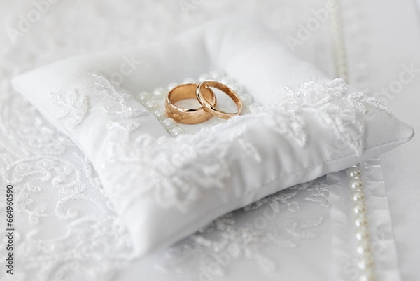 Obraz gold wedding rings on a beautiful lace pillow embroidered with pearls