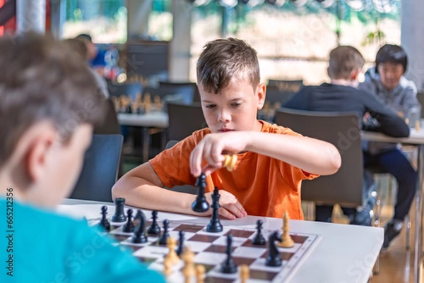 Fototapeta A school kid taking part in a chess tournament 
