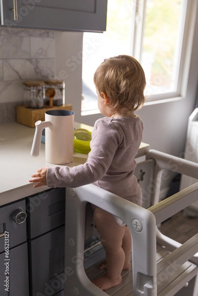 Obraz Toddler playing in the kitchen with household objects