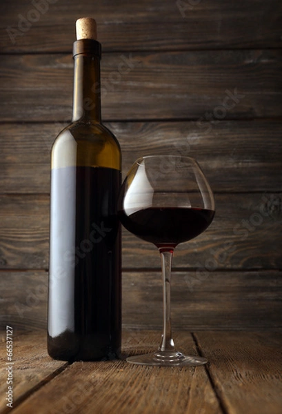 Fototapeta Bottles of wine with glass on wooden background