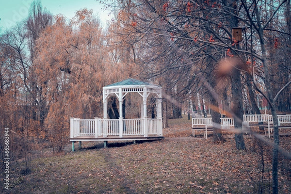 Obraz A white rotunda, with a green roof, in an autumn park. A bright autumn park with a beautiful white rotunda.