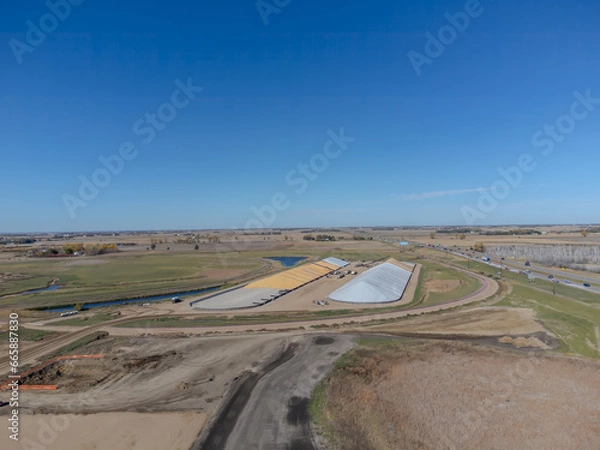 Fototapeta Drone view over two grain storage piles being filled and covered