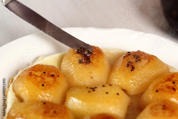 Fototapeta Garnishing tart with caramelized sugar with cardamom seeds. Making Pear Tarte Tatin with Cardamom series.