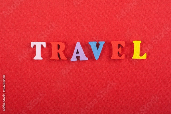 Fototapeta TRAVEL word on red background composed from colorful abc alphabet block wooden letters, copy space for ad text. Learning english concept.
