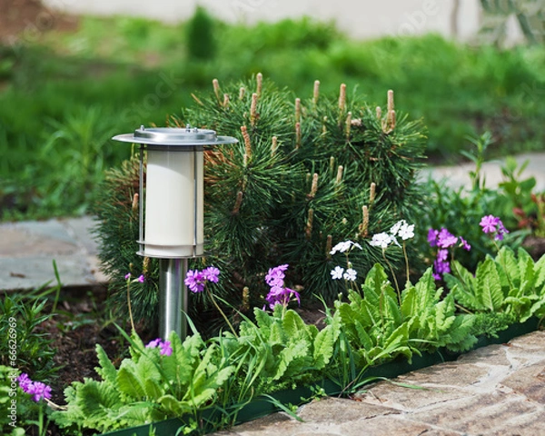 Fototapeta Solar-powered lamp on garden background.