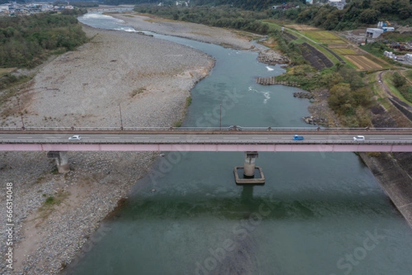 Obraz ドローン撮影：信濃川の上にかかる橋と、その上を走る車	