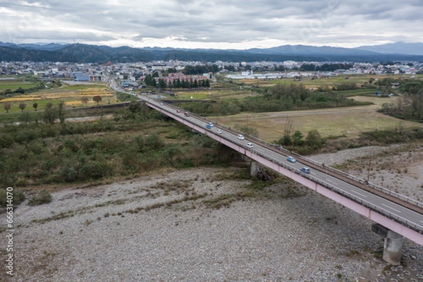 Obraz ドローン撮影：信濃川の上にかかる橋と、その上を走る車	