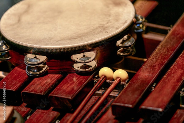 Fototapeta tambourine and drumsticks lie on a wooden xylophone