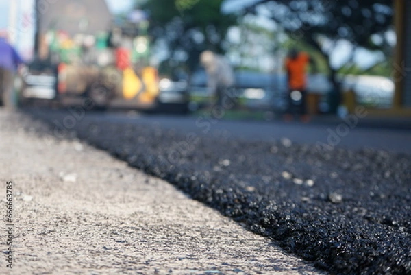 Fototapeta Blurred image of paving surface with heavy machinery