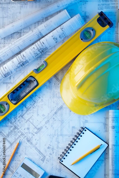 Fototapeta Architect and contractor concept. Rolls with projects. Tool kit of the contractor: yellow hardhat, libella and notebook. 