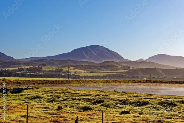 Fototapeta Small dam on farm in early morning light with mountains in background near Riversdale in the Western Cape, South Africa