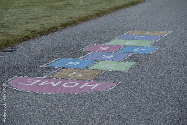 Fototapeta Brightly colored hopscotch squares in a public playground 