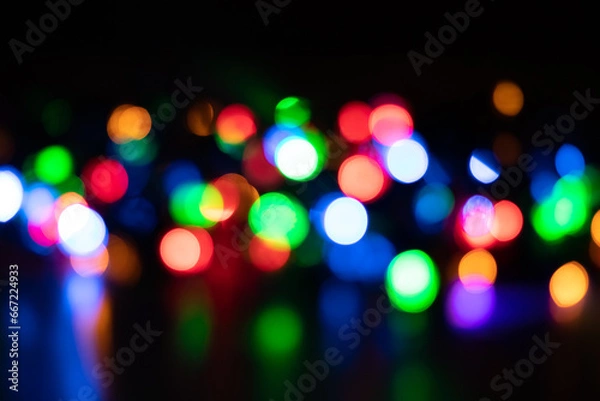 Fototapeta Festive Christmas and New Year background with bokeh, blurred lights on black background