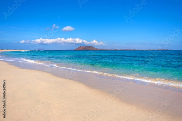 Fototapeta View on Corralejo beach and Lobos island, blue water and golden sand and the Canary Island Fuerteventura, Spain.