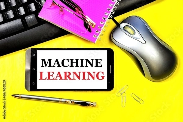 Fototapeta Machine learning. The inscription on the smartphone screen on the background of a computer keyboard, mouse and notepad for notes.