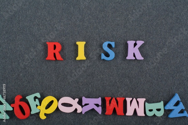 Fototapeta RISK word on black board background composed from colorful abc alphabet block wooden letters, copy space for ad text. Learning english concept.