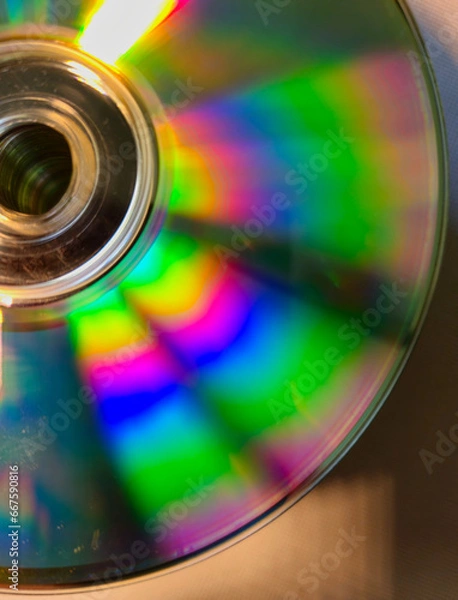 Obraz Close-up to interesting abstract patterns created by the rays of sunlight reflecting from the surface of the CD lying on the desk, Lodz, Poland.