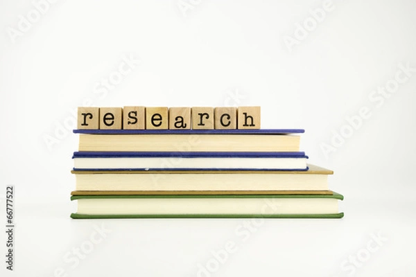 Obraz research word on wood stamps and books