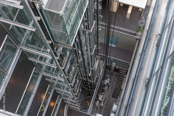 Fototapeta Looking downwards in a modern open elevator shaft
