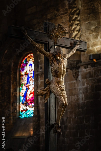 Obraz Painted wooden sculpture of Jesus Christ being crucified