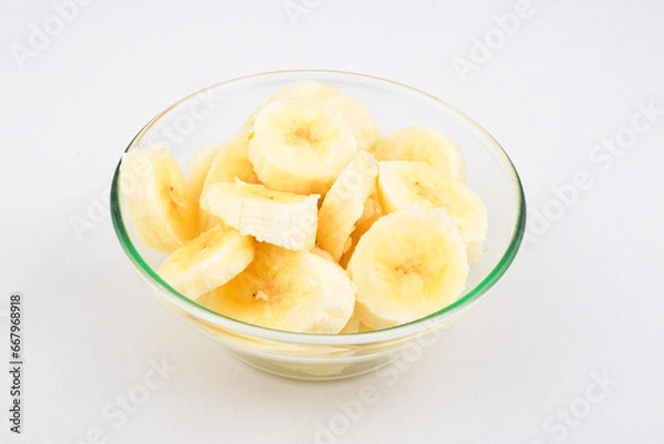Fototapeta Banana slice in bowl on white background