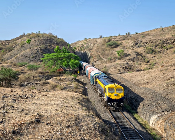 Obraz Goods train coming out of a huge hill cutting in Ambale, Maharashtra, India.