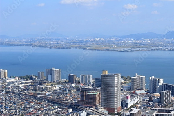 Obraz 滋賀県　大津京駅周辺のビルと琵琶湖対岸の草津市の風景