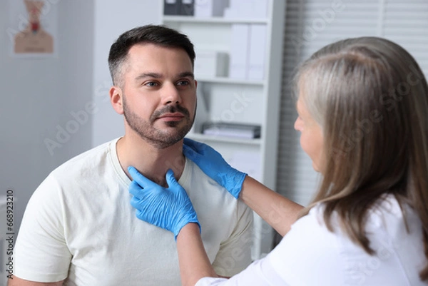 Obraz Endocrinologist examining thyroid gland of patient at hospital