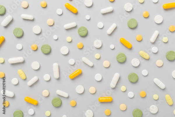 Fototapeta Flat lay with different medical pills and capsules on color background