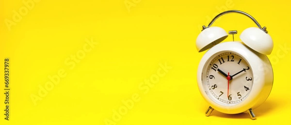 Fototapeta vintage retro alarm clock Four o'clock, ten minutes on yellow background.