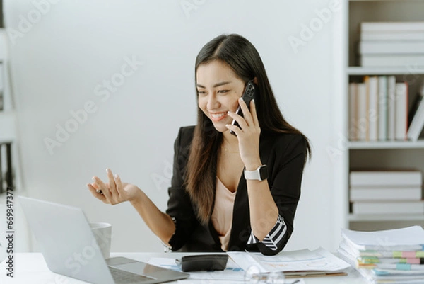 Fototapeta Asian woman sitting at a desk working in the office use a computer, laptop