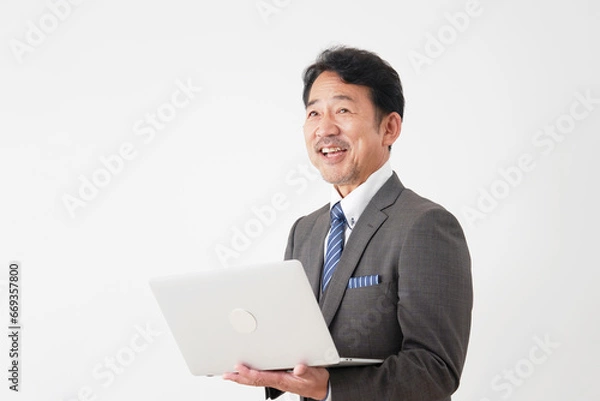 Fototapeta ノートパソコンを使う中年のビジネスマン　白背景