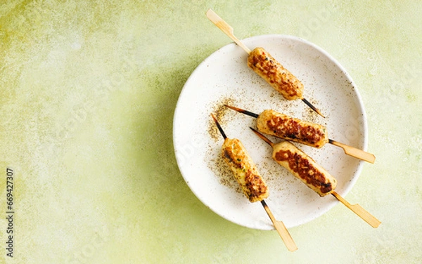 Fototapeta Juicy chicken kebab on a plate. Skewers. Food background with copy space. Top view.