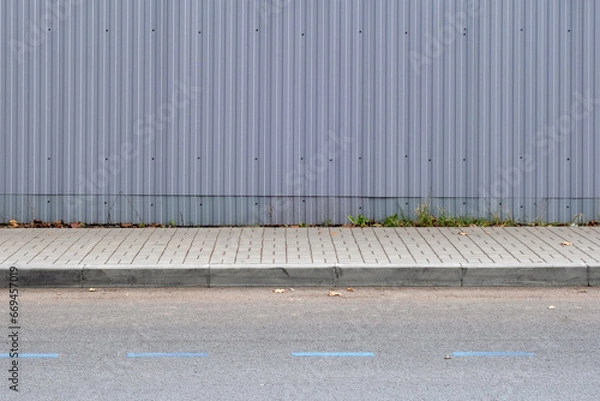 Fototapeta Gray metal fence along the sidewalk