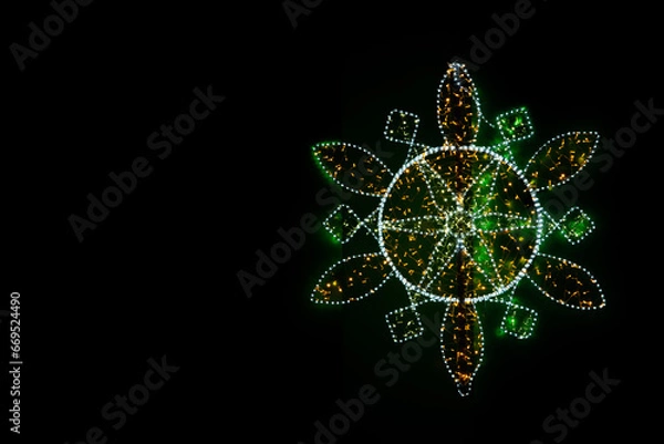 Fototapeta New Year's garlands are stretched in the form of a multifaceted snowflake. A bright bokeh of the lights of New Year's garlands.